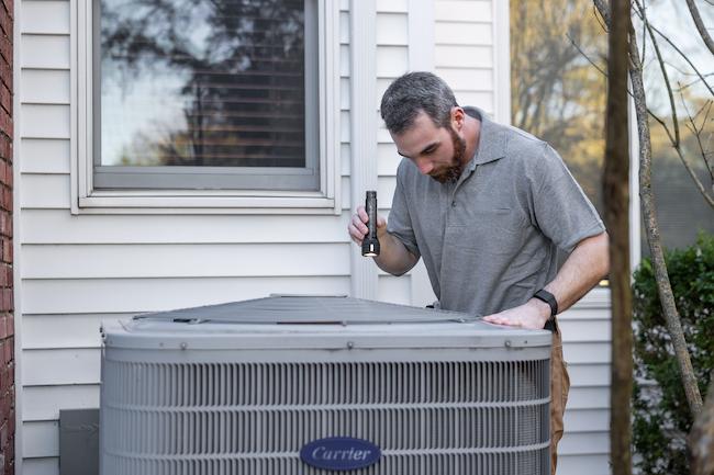HVAC technician servicing an air conditioning unit at a Texas home